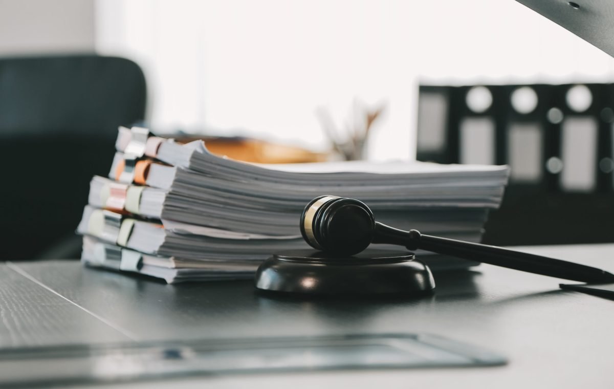 Business and lawyers discussing contract papers with brass scale on desk in office. Law, legal services, advice, justice and law concept picture with film grain effect